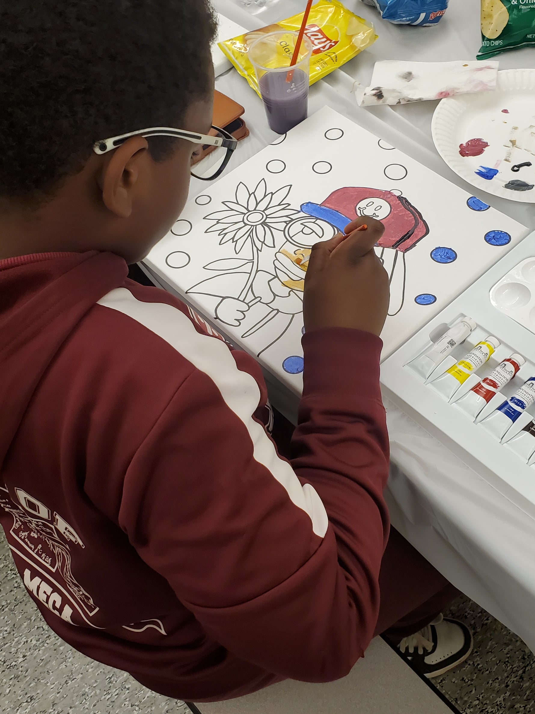 Kid painting a Stapledon Arts paint kit at a table